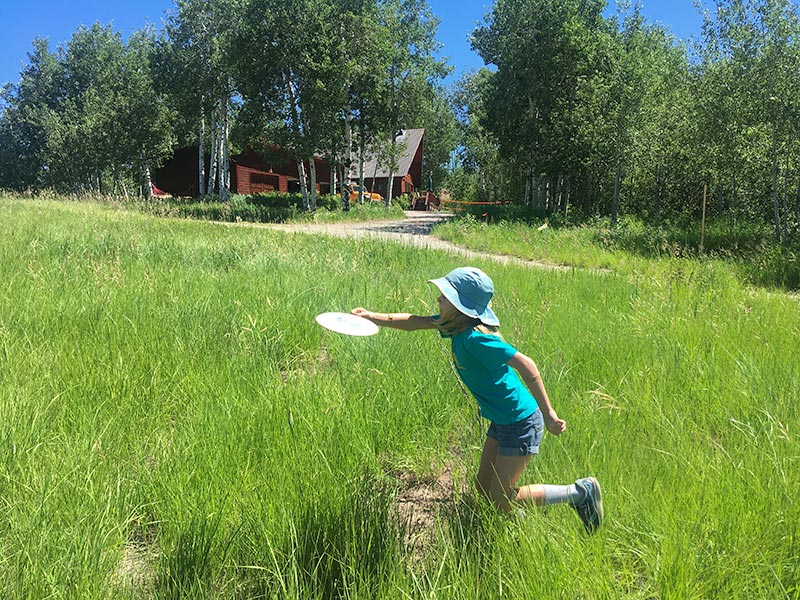 Disc golf with horseshoe cabin in the background